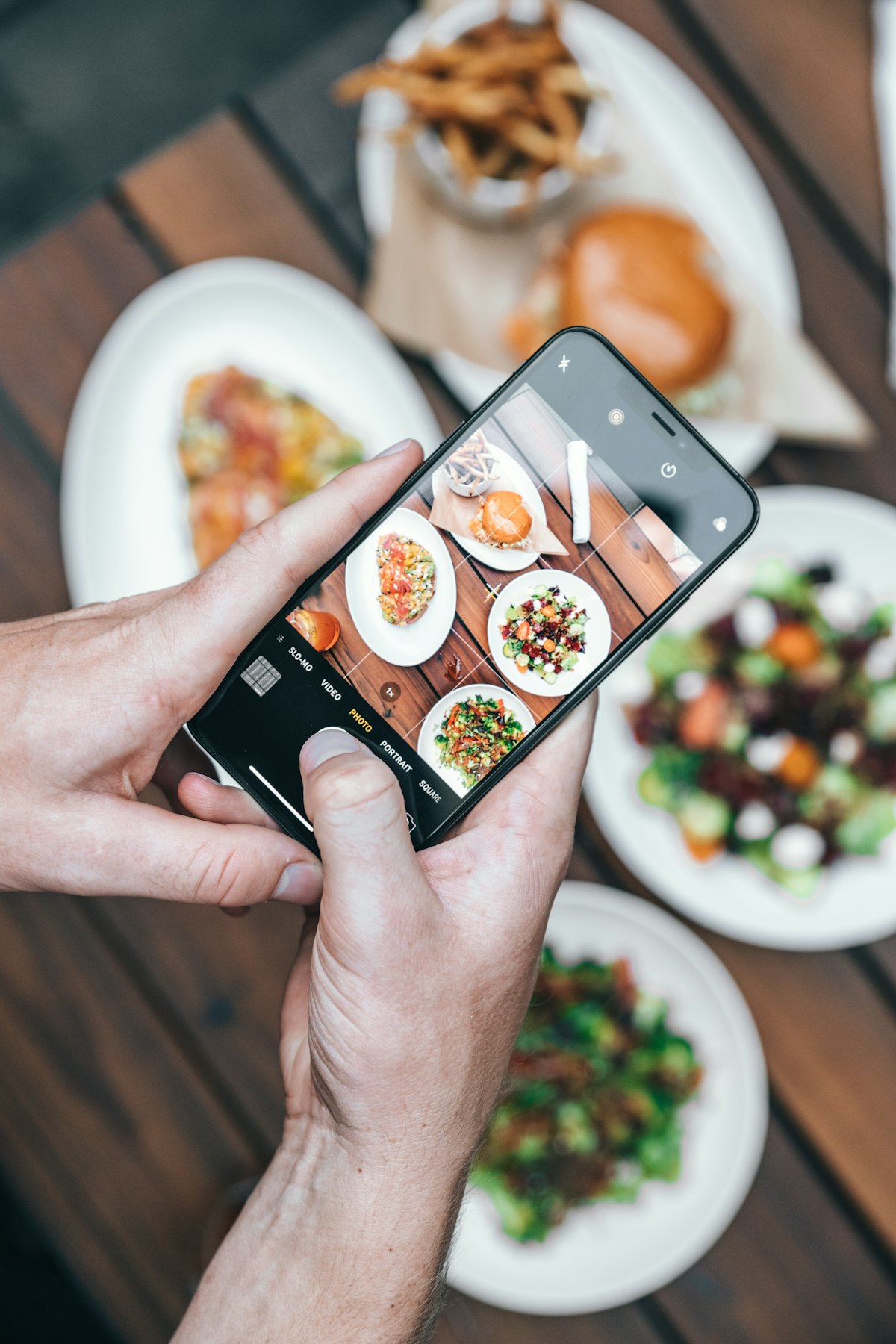 料理をスマートフォンで撮影してGoogleマップやSNSに口コミを投稿する飲食店の利用客