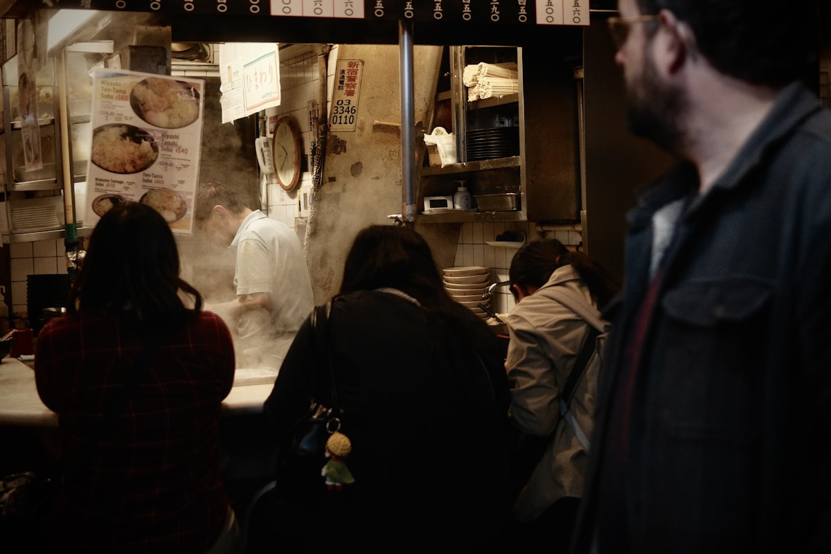カウンター席で一人客が食事を楽しむ日本の飲食店の店内